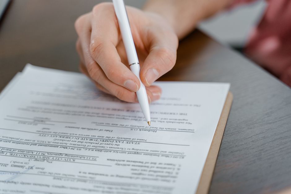 A writer making notes by hand at a bright table during the editorial process.