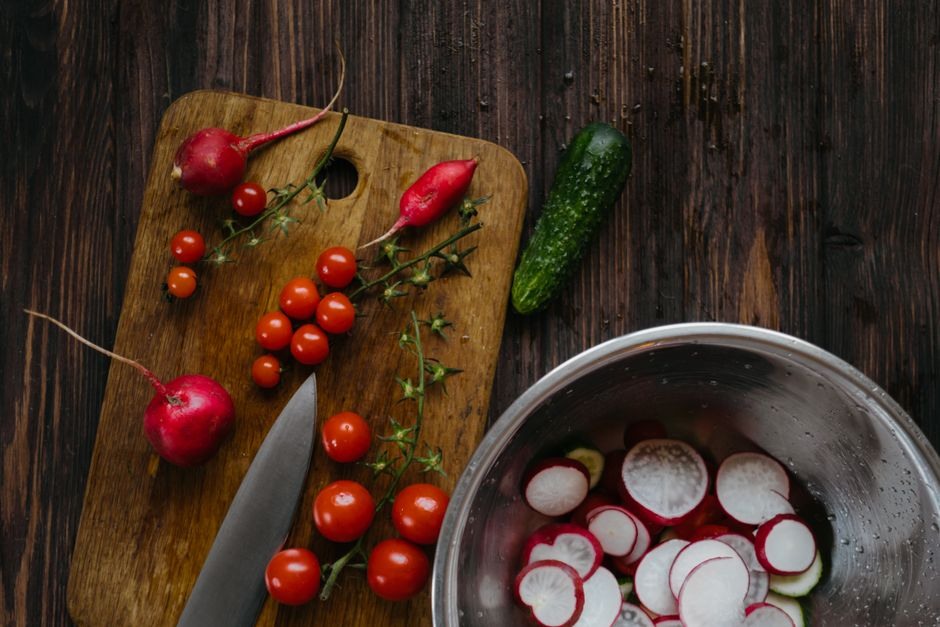 Fresh radishes, tomatoes, cucumber, and herbs arranged for a simple seasonal supper.